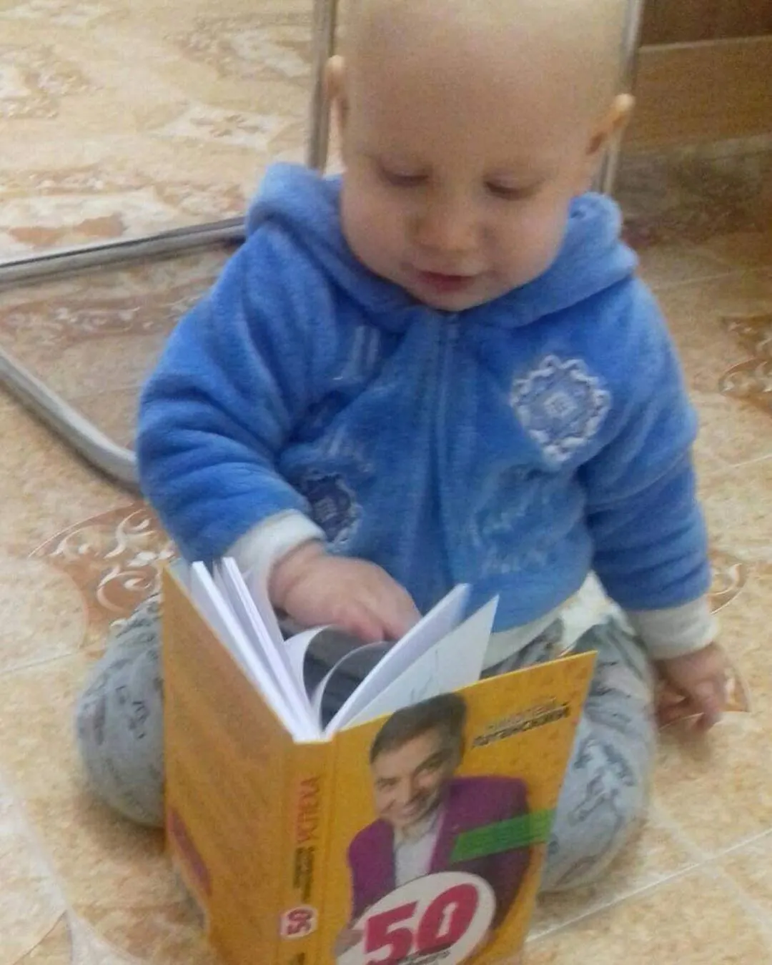 Вот прислали… Ребёнку годик, а он среди огромного множества книг обширной библиотеки своей мамы — известной писательницы(!) —